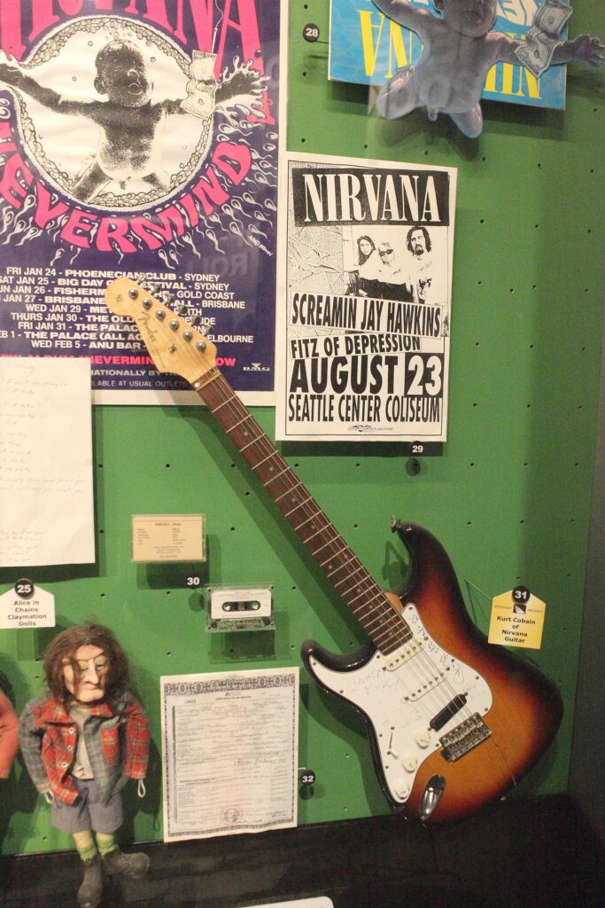 Nirvana posters, a Nevermind promotional poster and a smashed guitar on display at the Rock and Roll Hall of Fame in Cleveland